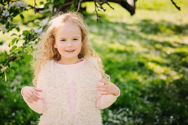 Jarní portrét krásné zasněný kudrnaté 5 let staré dítě dívka procházky v rozkvetlé zahradě — Stock fotografie