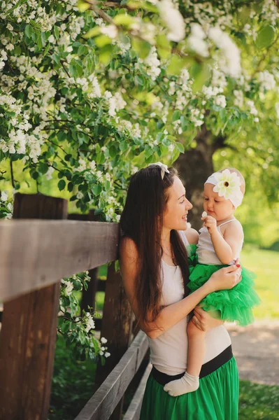 Retrato de primavera de mãe e bebê filha jogando ao ar livre em roupa combinando - saias longas e camisas. Família feliz enjoyng férias — Fotografia de Stock