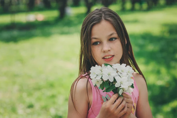 Primavera primer plano retrato al aire libre de adorable 11 años de edad niña preadolescente. Pasar las vacaciones de primavera en un hermoso jardín de cerezos en flor — Foto de Stock