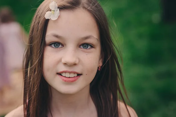 Printemps gros plan portrait en plein air de adorable jeune fille de 11 ans. Passer les vacances de printemps dans un magnifique jardin de cerisiers en fleurs — Photo