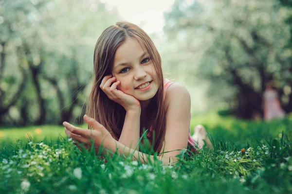 Весенний крупным планом наружный портрет очаровательной 11-летней девочки-подростка. Весенние каникулы в красивом цветущем вишневом саду — стоковое фото