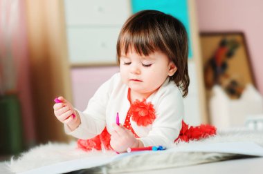 1 yaşındaki bebek kız evde kalemler ile çizim. Erken öğrenme ve eğitim kavramı 