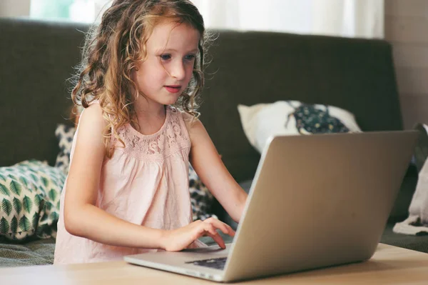 Enfant heureux en utilisant un ordinateur portable à la maison. École fille apprentissage avec ordinateur et internet intérieur . — Photo