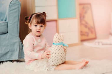 evde oyuncakları ile oynarken şirin mutlu 2 yaşında bebek kız. Modern kreş iç pastele sesleri, erken kavram öğrenme