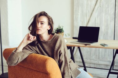 Genç başarılı blogger veya evde online laptop ve kahve ile sabah çalışan iş kadını. Modern İskandinav iç ev ofis