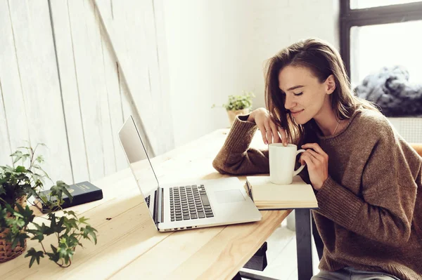年轻学生女人在线在家里用笔记本电脑在早上学习杯咖啡. — 图库照片