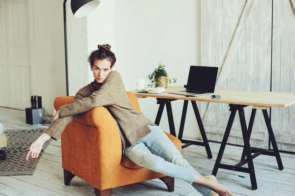Genç başarılı blogger veya evde online laptop ve kahve ile sabah çalışan iş kadını. Modern İskandinav iç ev ofis