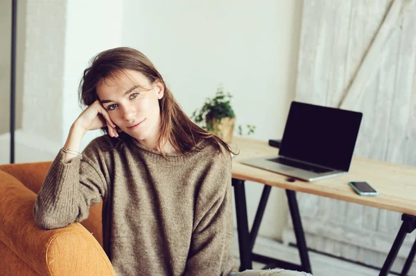 Junge erfolgreiche Bloggerin oder Geschäftsfrau, die morgens mit Laptop und Tasse Kaffee zu Hause online arbeitet. Home Office im modernen skandinavischen Interieur — Stockfoto