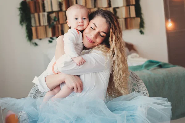 Evde mutlu bir aile. Anne bebek evlat yatak odasında sıcak hafta sonu sabah holding. — Stok fotoğraf