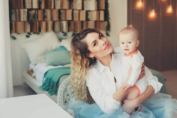 Famille heureuse à la maison. Mère tenant bébé fils dans la chambre dans le week-end matin confortable — Photo