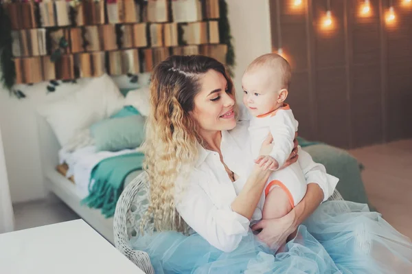 Famille heureuse à la maison. Mère tenant bébé fils dans la chambre dans le week-end matin confortable — Photo