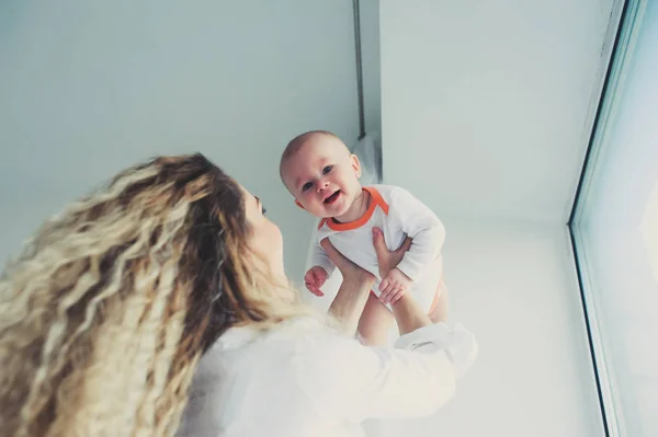 Evde mutlu bir aile. Anne bebek evlat yatak odasında sıcak hafta sonu sabah holding. — Stok fotoğraf