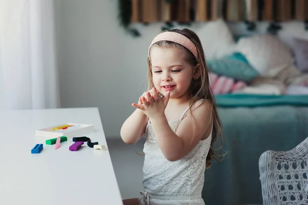 Cute toddler girl playing with plasticine or play dough at home. Child learning to work with modelling clay — Stock Photo, Image