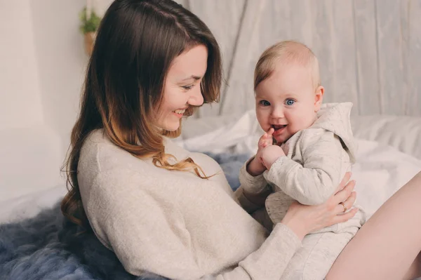 Mère heureuse et bébé jouant à la maison dans la chambre. Style de vie familial confortable dans l'intérieur scandinave moderne . — Photo