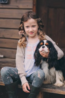 merdiven ahşap kulübede oturan spaniel köpeği ile oynayan kız çocuk