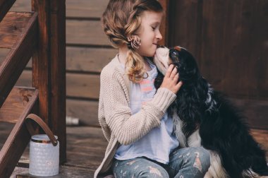 merdiven ahşap kulübede oturan spaniel köpeği ile oynayan kız çocuk