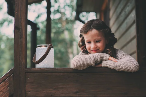 Bambina con portacandele relax serale in accogliente casa di campagna. Bambino che trascorre le vacanze estive in baita nel bosco — Foto Stock