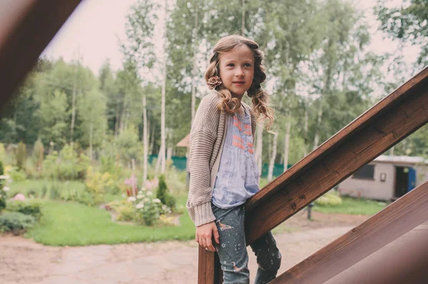 Kid flicka som leker på trä stuga i skogen. Barn spendera sommarlovet utomhus på country house — Stockfoto