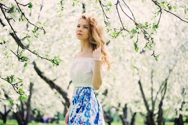 Mooie jonge vrouw in floral maxi rok wandelen in het voorjaar — Stockfoto