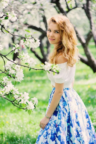 Hermosa joven en falda maxi floral caminando en primavera — Foto de Stock