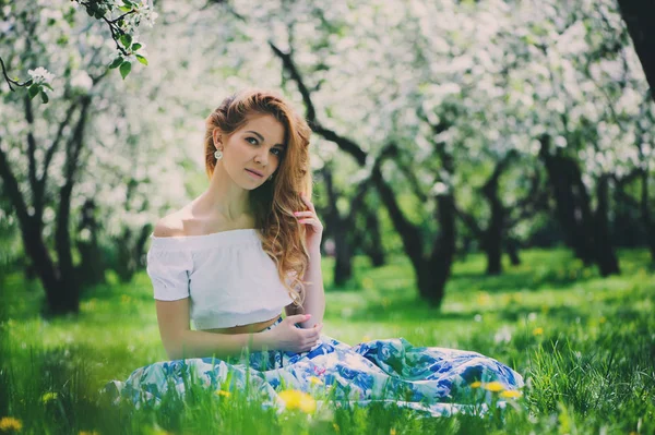 Hermosa joven en falda maxi floral caminando en primavera —  Fotos de Stock