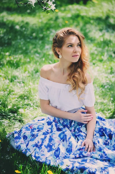 Hermosa joven en falda maxi floral caminando en primavera — Foto de Stock