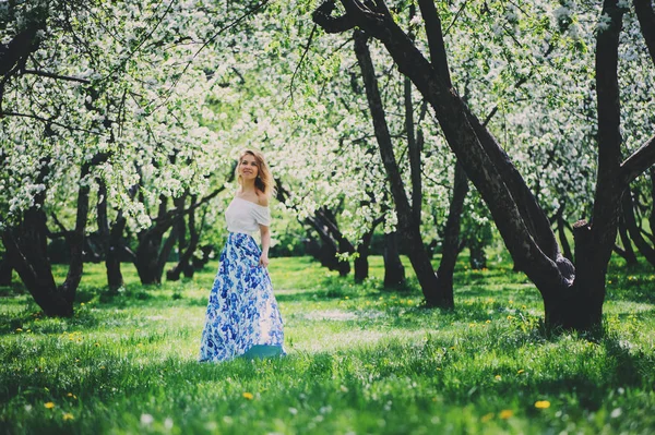 Bela jovem mulher em saia maxi floral andando na primavera — Fotografia de Stock