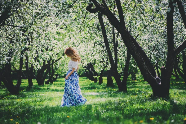 Bela jovem mulher em saia maxi floral andando na primavera — Fotografia de Stock