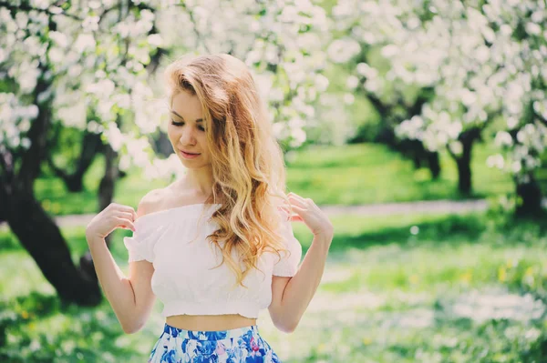 Hermosa joven en falda maxi floral caminando en primavera —  Fotos de Stock