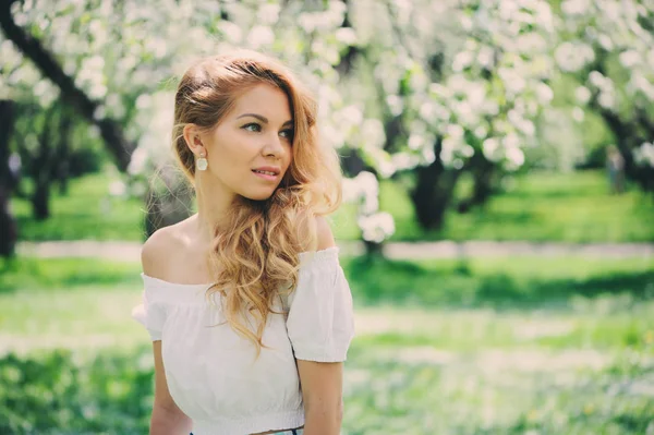 Hermosa joven en falda maxi floral caminando en primavera — Foto de Stock