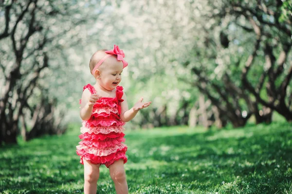 귀여운 행복 한 아기 소녀 재미 핑크 장난 산책에 야외 봄 정원에서. 행복 한 유년 시절 개념 — 스톡 사진