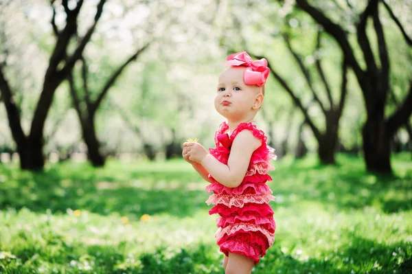 可爱的开心宝贝女孩有趣的粉色爬衣行走户外在春天的花园。快乐的童年概念 — 图库照片