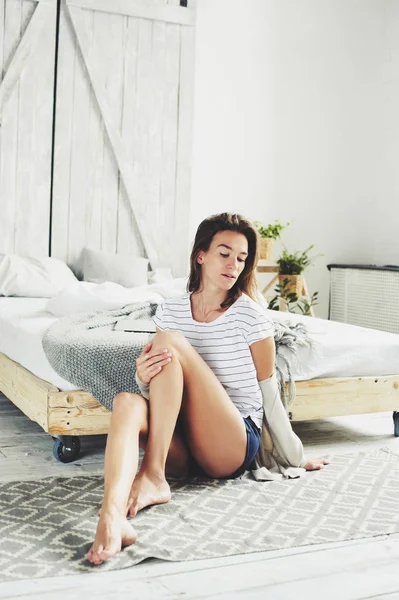 Hermosa mujer sexy femenina joven que se relaja en el dormitorio en la mañana de fin de semana perezoso, con ropa de moda casual — Foto de Stock