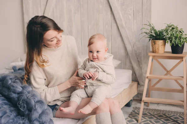 mutlu anne ve bebek yatak odalı evde oynarken. Rahat aile yaşam tarzı modern İskandinav iç. 