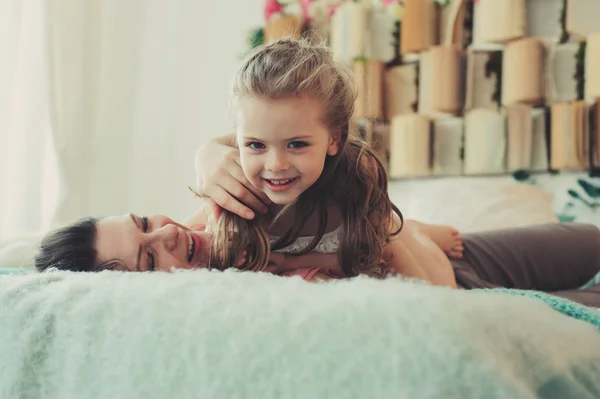 Famille heureuse jouant à la maison. Mère et fille tout-petit se détendre et s'amuser au lit le week-end matin confortable — Photo