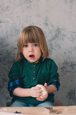 Anne mutfakta çocuklarla yemek. Birlikte pişirme ve hafta sonu sabah evde pasta ile oynarken yürümeye başlayan kardeşler