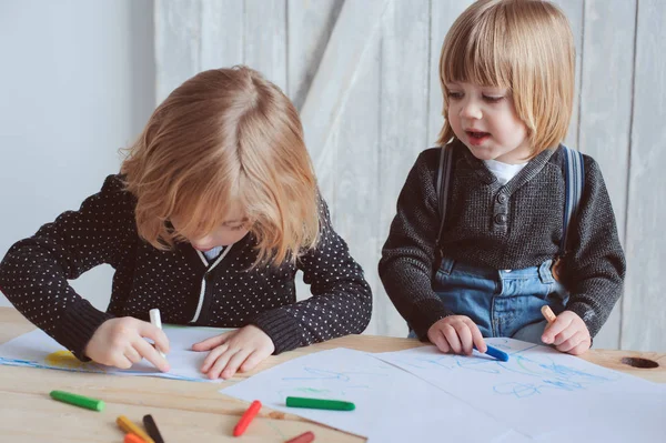 Dos hermanos pequeños dibujando juntos en casa. Felices hermanos pasando tiempo juntos y jugando . — Foto de Stock