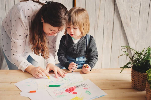 Madre enseñando a niño a dibujar con lápices en casa. Familia pasar tiempo juntos — Foto de Stock