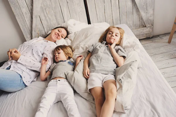 母親が子供 2 人の息子、朝の寝室でリラックス — ストック写真