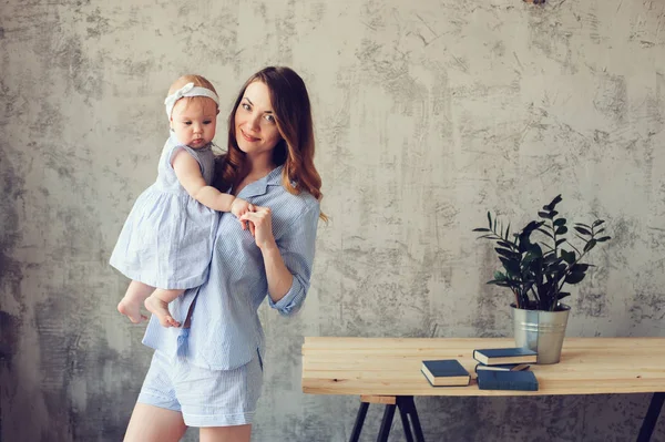 Gelukkig moeder en baby spelen thuis in de slaapkamer. Gezellige familie levensstijl in moderne Scandinavische interieur. — Stockfoto