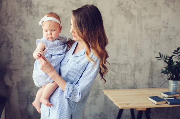 Gelukkig moeder en baby spelen thuis in de slaapkamer. Gezellige familie levensstijl in moderne Scandinavische interieur. — Stockfoto