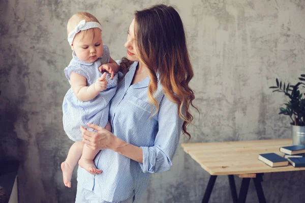 Feliz madre y bebé jugando en casa en el dormitorio. Acogedor estilo de vida familiar en el interior escandinavo moderno . — Foto de Stock