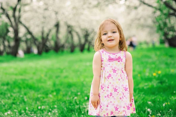 Ładny mały szczęśliwy toddler dziewczynka portret spacery wiosną lub latem park lub ogród — Zdjęcie stockowe