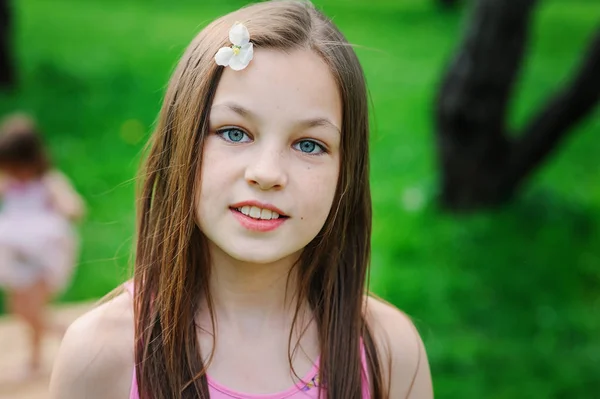 Spring closeup outdoor portrait of adorable 11 years old preteen kid girl. Spending spring holidays in beautiful blooming garden — Stock Photo, Image