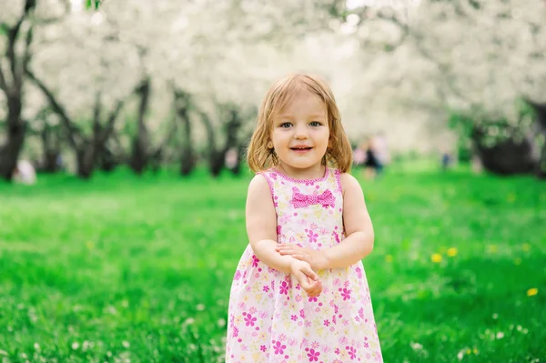 Séta a tavaszi vagy nyári parkban vagy kertben aranyos kis kisgyermek boldog lány portréja — Stock Fotó