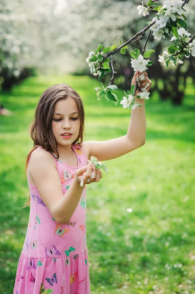 Spring closeup outdoor portrait of adorable 11 years old preteen kid girl. Spending spring holidays in beautiful blooming garden — Stock Photo, Image