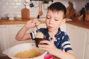 rahat modern beyaz mutfakta kek hamuru hazırlama çocuk evlat. Çocuklar evde yemek