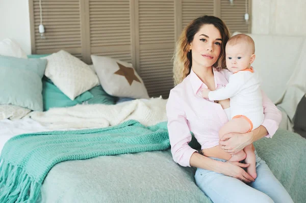 Famille heureuse à la maison. Mère tenant bébé fils dans la chambre dans le week-end matin confortable — Photo