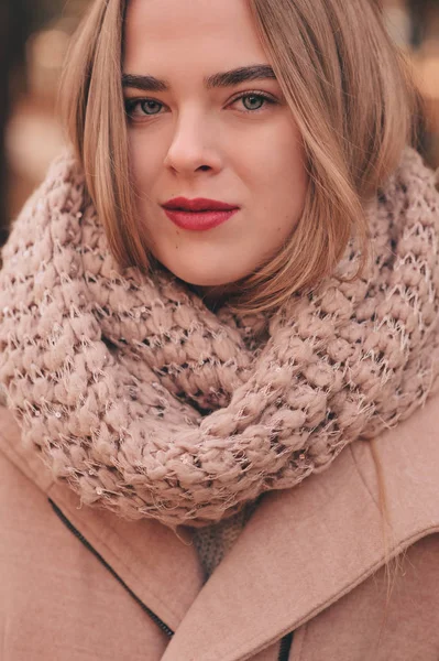 Portret van jonge mooie vrouw wandelen in stijlvolle warme outfit in zonnige herfstdag in park, het dragen van roze jas en gebreide haarband. Ongedwongen levensstijl in de stad — Stockfoto