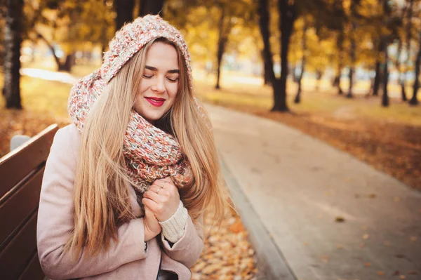 Retrato da jovem mulher bonita andando em roupa quente elegante no dia ensolarado de outono no parque, vestindo casaco rosa e snood de malha. Estilo de vida casual na cidade — Fotografia de Stock